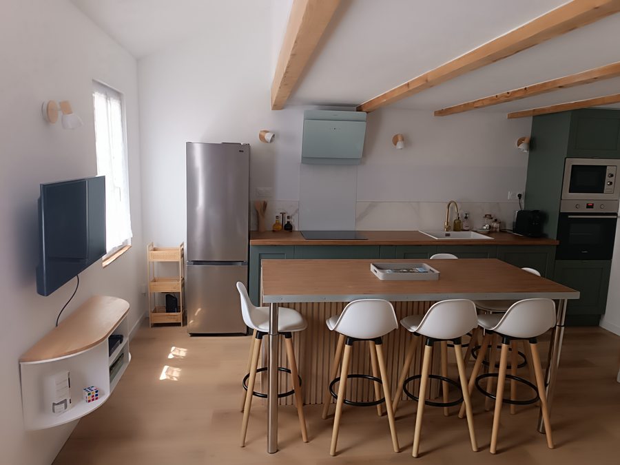 Open living room and kitchen with wooden island and exposed beams